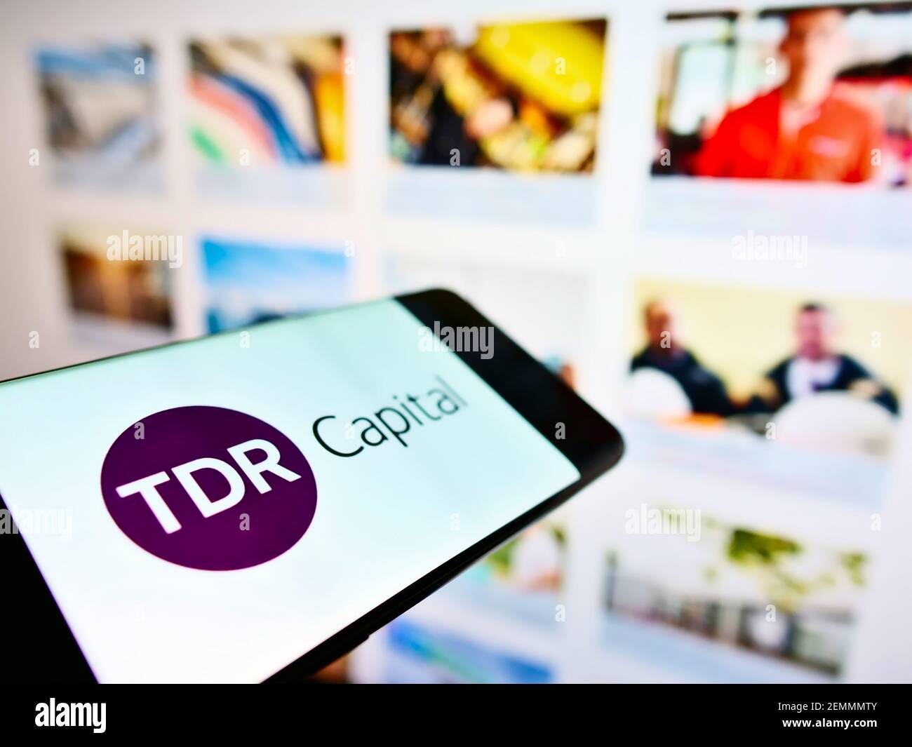 Cellulare con logo commerciale della società di investimento britannica TDR Capital LLP sullo schermo davanti alla pagina web. Mettere a fuoco al centro-sinistra del display del telefono. Foto Stock