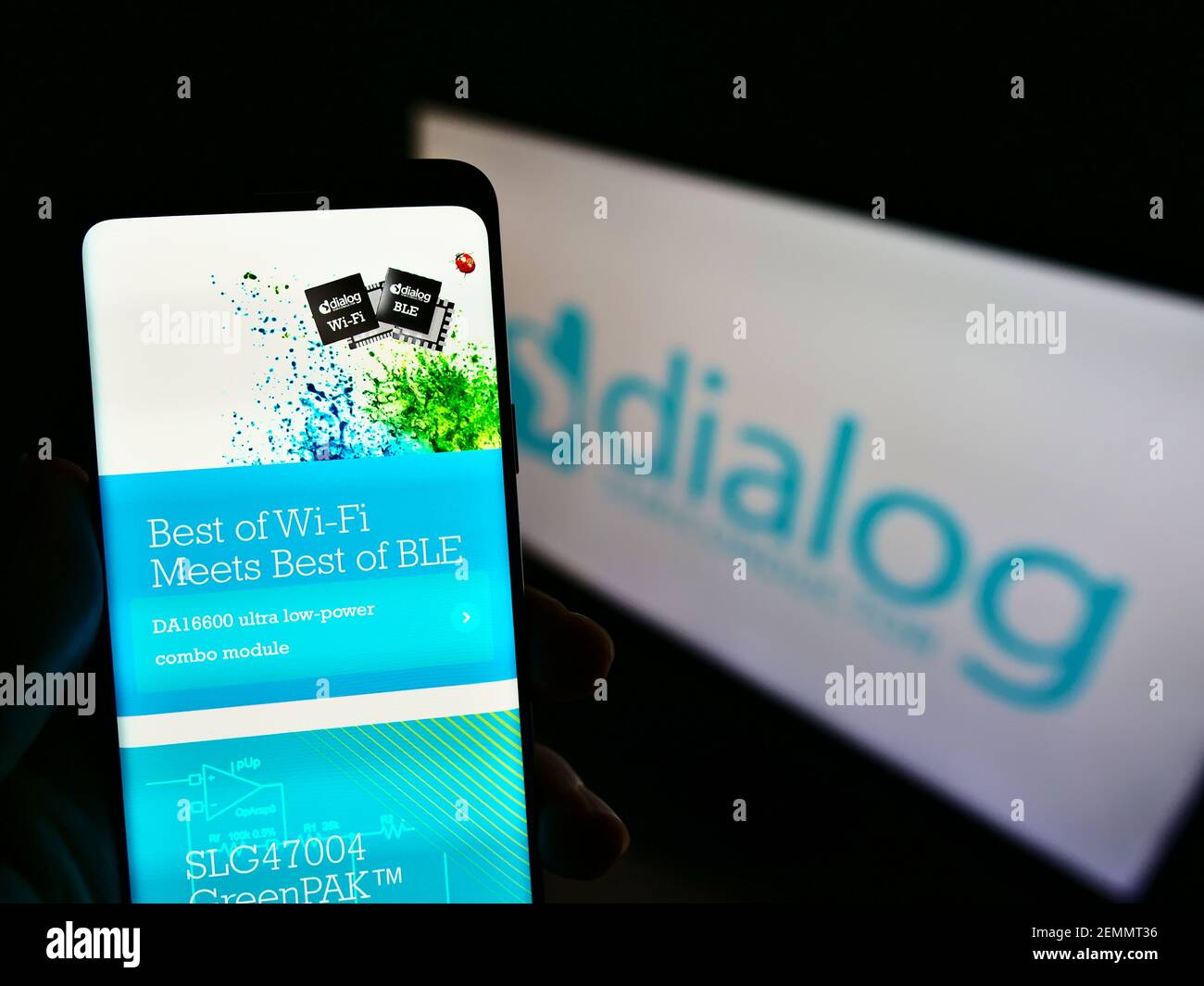 Persona titolare di telefono cellulare con sito web della società di ingegneria Dialogue Semiconductor PLC su schermo con sito web. Mettere a fuoco il centro del display del telefono. Foto Stock
