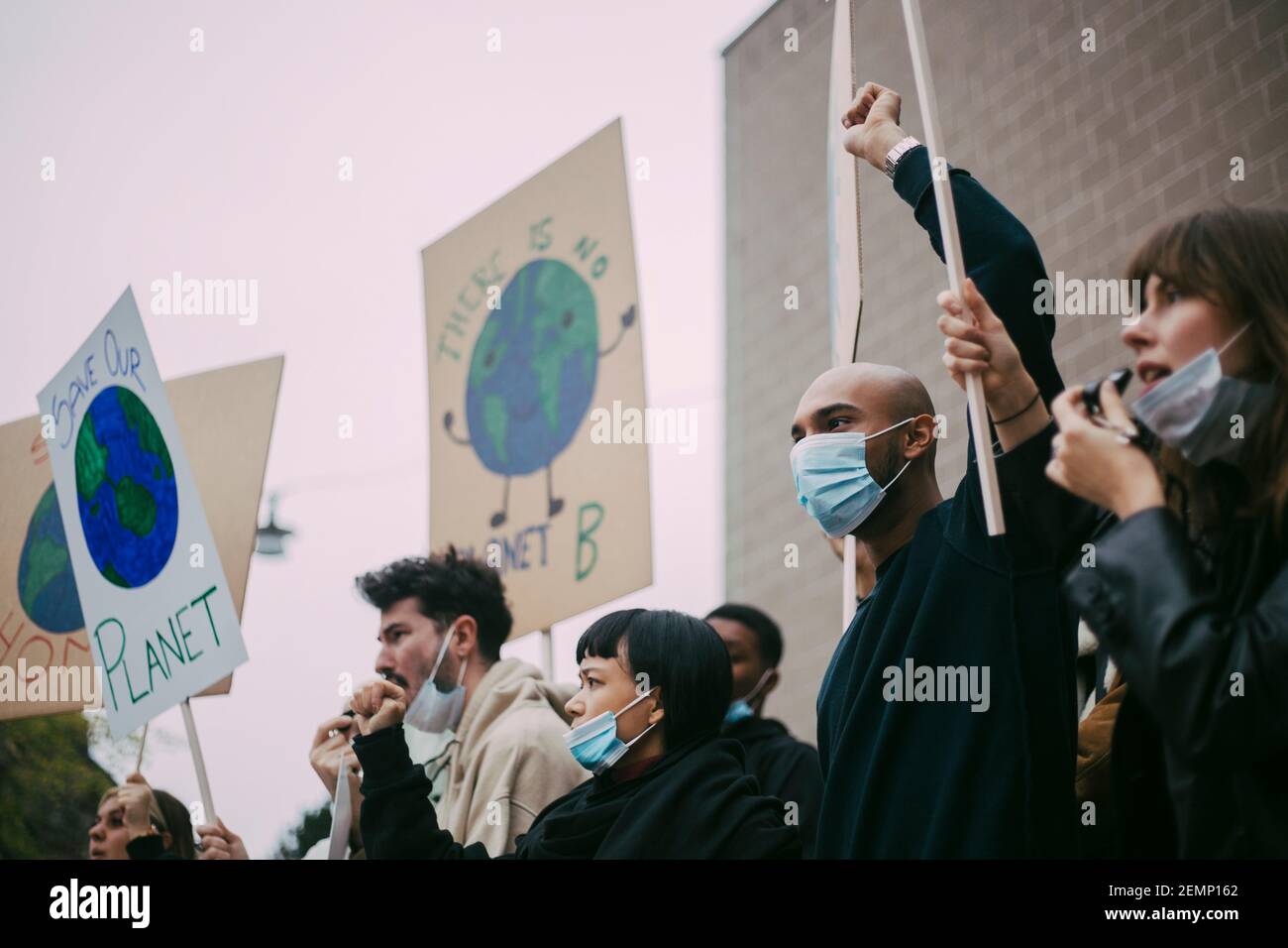 Attivisti maschili e femminili che protestano per problemi ambientali durante la pandemia Foto Stock