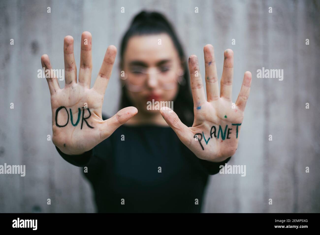 Il nostro testo del pianeta scritto sulle palme dell'attivista femminile Foto Stock