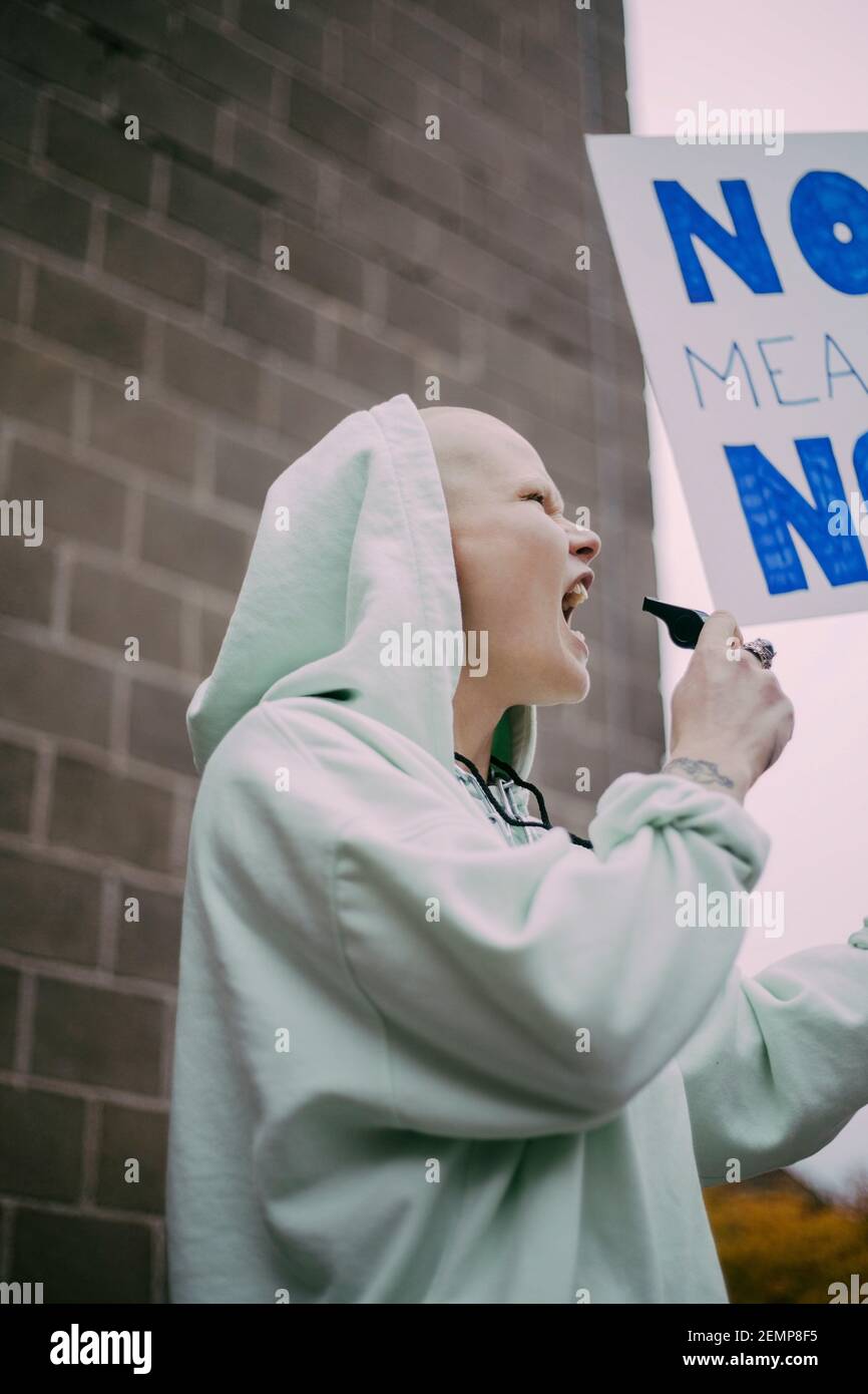 Una donna che urla con un cartello durante il movimento sociale Foto Stock