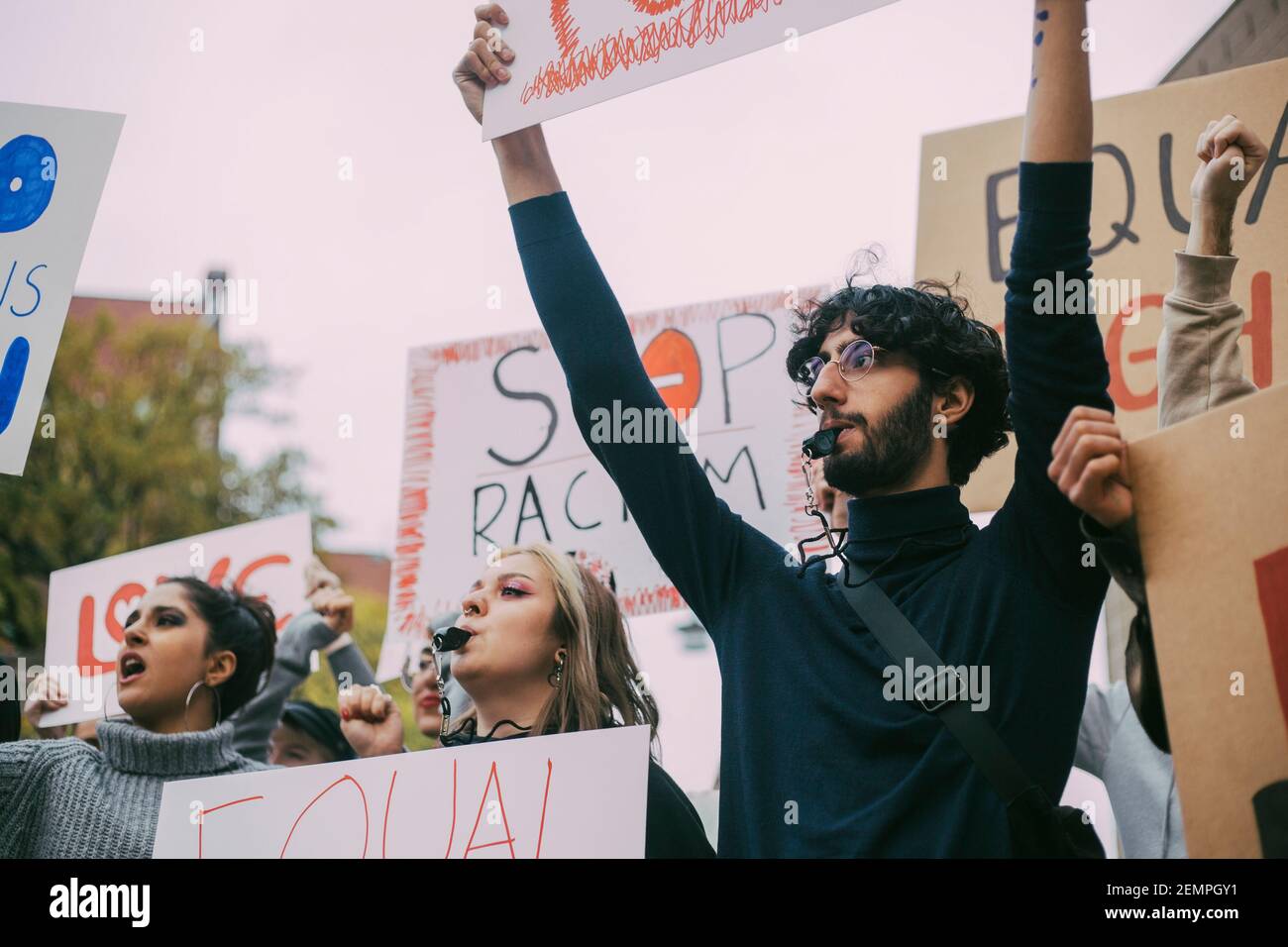 Attivista maschile e femminile che partecipa alla protesta contro il razzismo Foto Stock