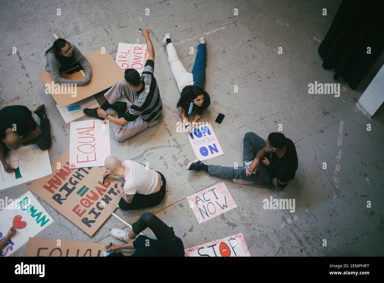 Vista ad angolo alto di manifestanti femminili e maschili che preparano cartelli per i diritti umani Foto Stock