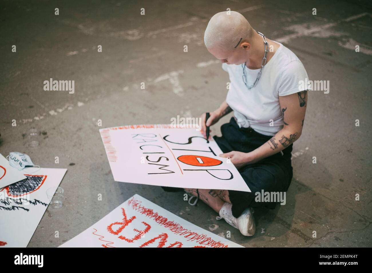Attivista femminile che prepara il cartello per fermare il razzismo Foto Stock
