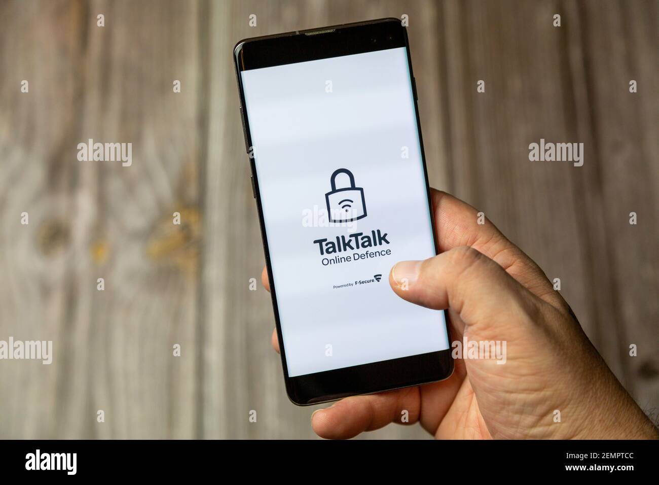 Un telefono cellulare o un telefono cellulare tenuto da un Con l'app di difesa online Talk aperta schermo Foto Stock