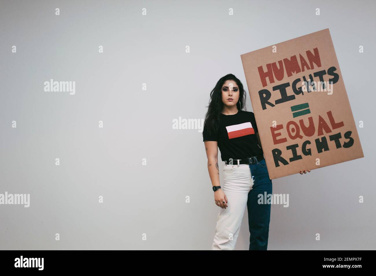 Ritratto di attivista femminile con cartello dei diritti umani contro il bianco parete Foto Stock