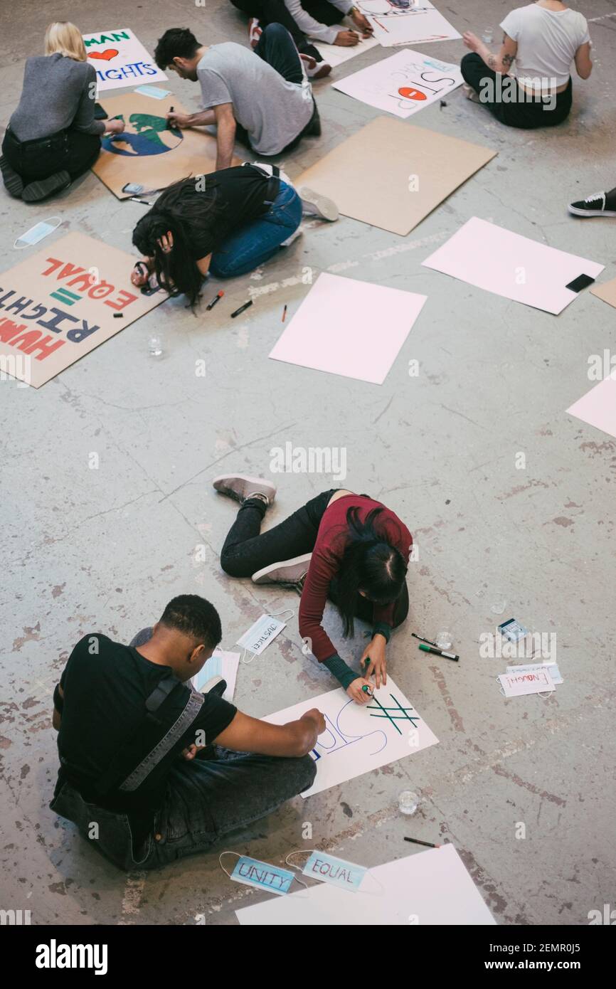 Vista ad angolo alto del cartello di preparazione attivista femminile e maschile per le questioni sociali Foto Stock