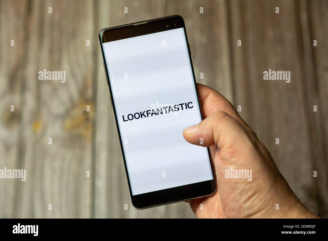 Un telefono cellulare o un telefono cellulare tenuto da un Mano con l'app look fantastico aperta sullo schermo Foto Stock