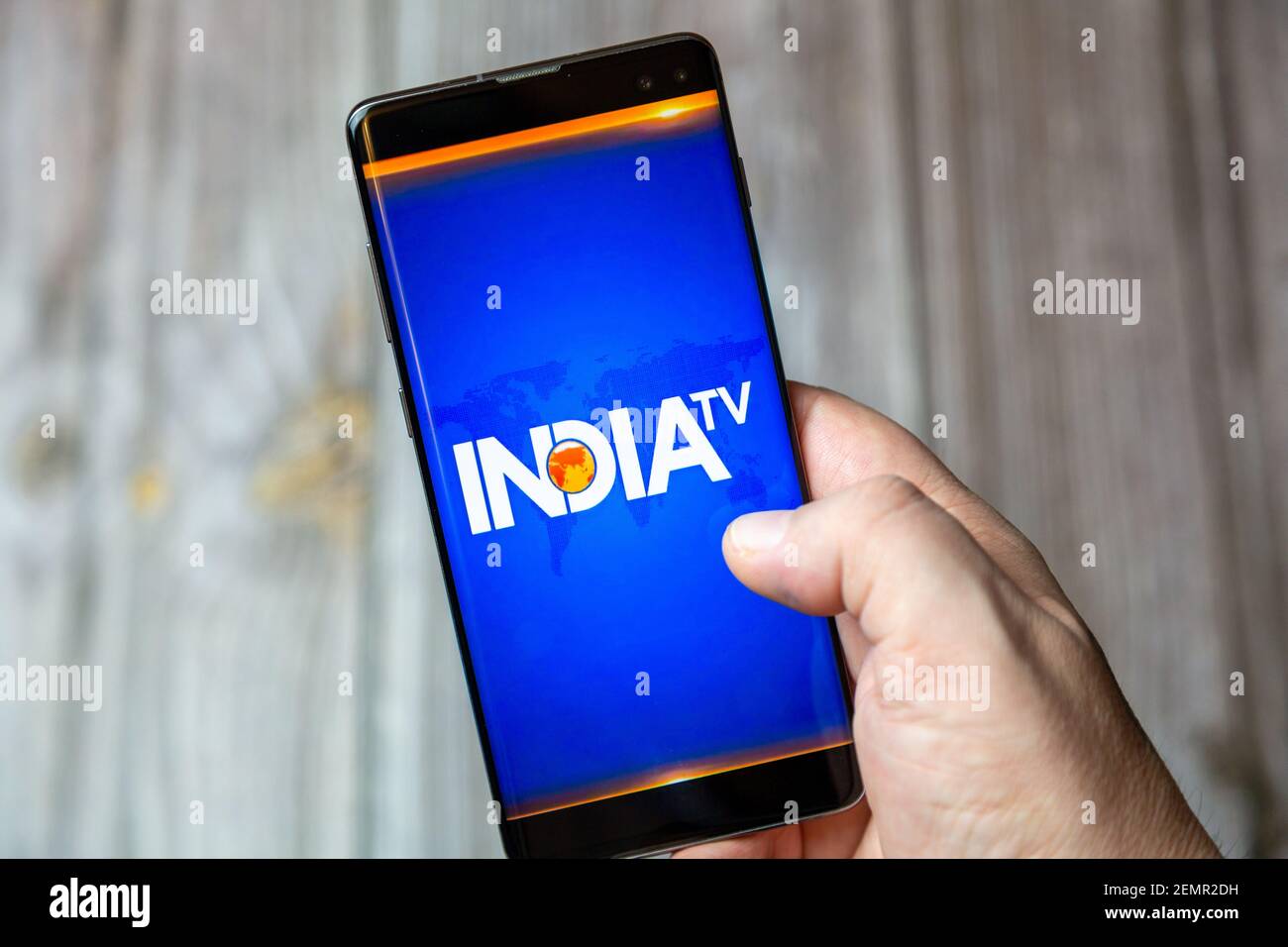 Un telefono cellulare o un telefono cellulare tenuto da un Mano con l'applicazione India TV aperta sullo schermo Foto Stock