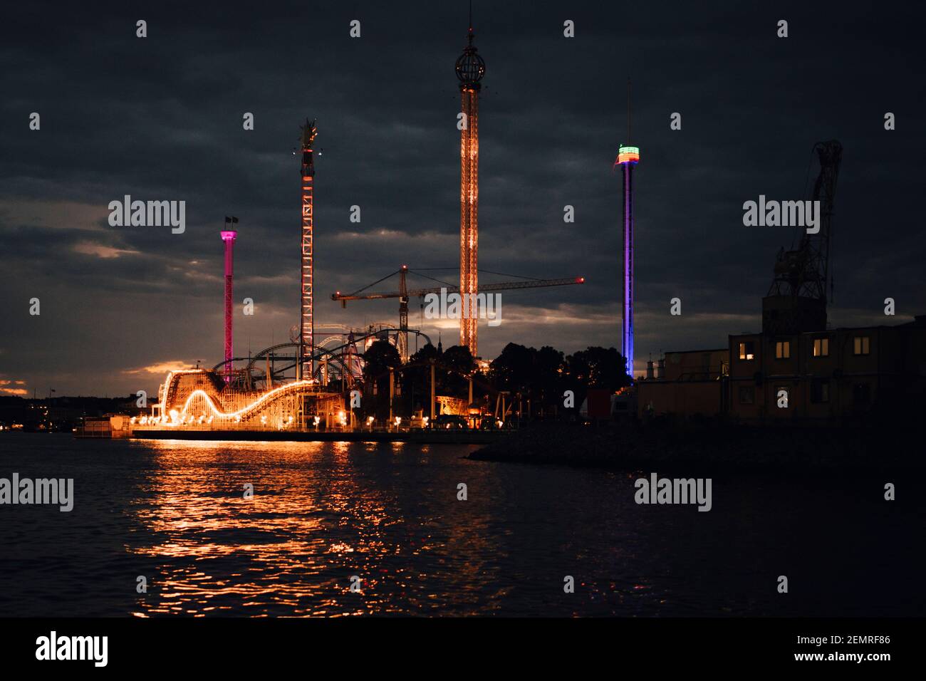 Parco divertimenti illuminato dal mare contro il cielo di notte Foto Stock