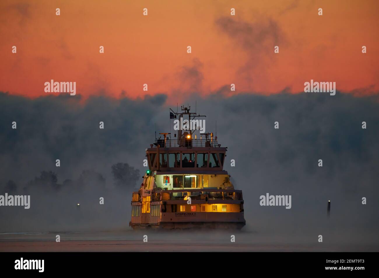 Helsinki, Finlandia - 15 gennaio 2021: Traghetto in arrivo a Kaupatori dall'isola della fortezza di Suomenlinna sul Mar Baltico in mezzo al fumo di mare o alla nebbia Foto Stock