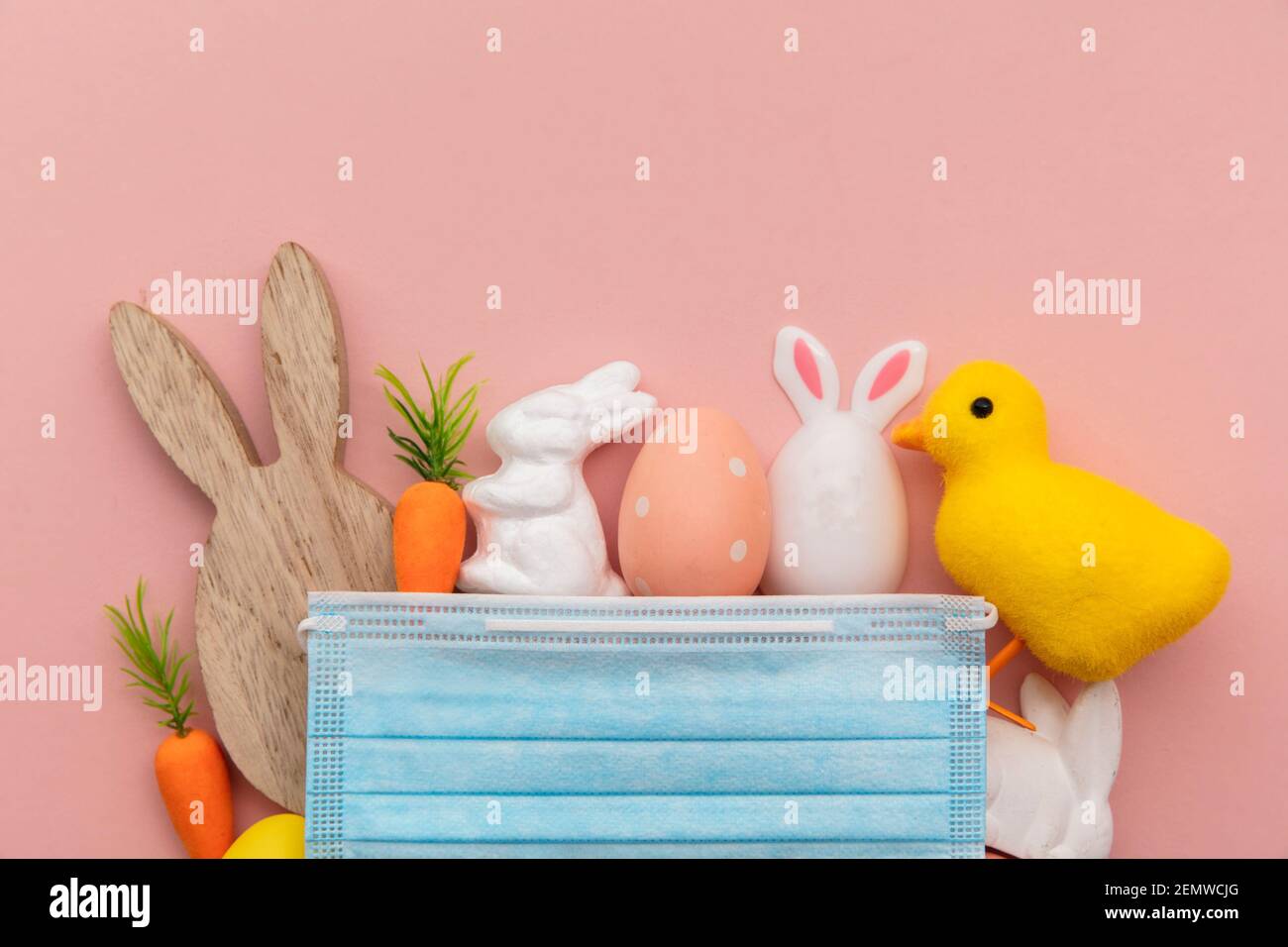 Pasqua primavera coronavirus sfondo. Maschera protettiva con decorazioni pasquali Foto Stock