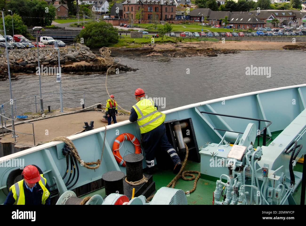 Marinai che gettano una linea dalla nave a riva come attracco nave, Brodick, Isola di Arran, Scozia Foto Stock