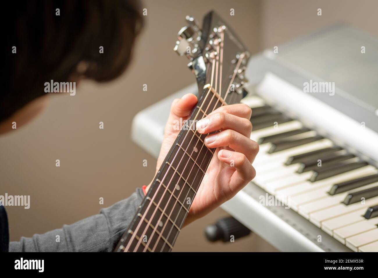 Primo piano di teenage boy che suona accordi su chitarra acustica, Londra,  Regno Unito Foto stock - Alamy