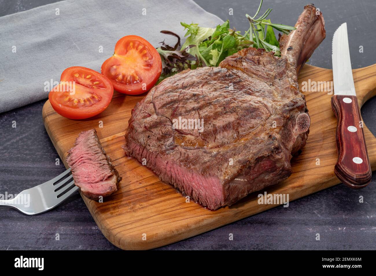 Bistecca di manzo al ribeye tomahawk alla griglia con insalata Foto Stock