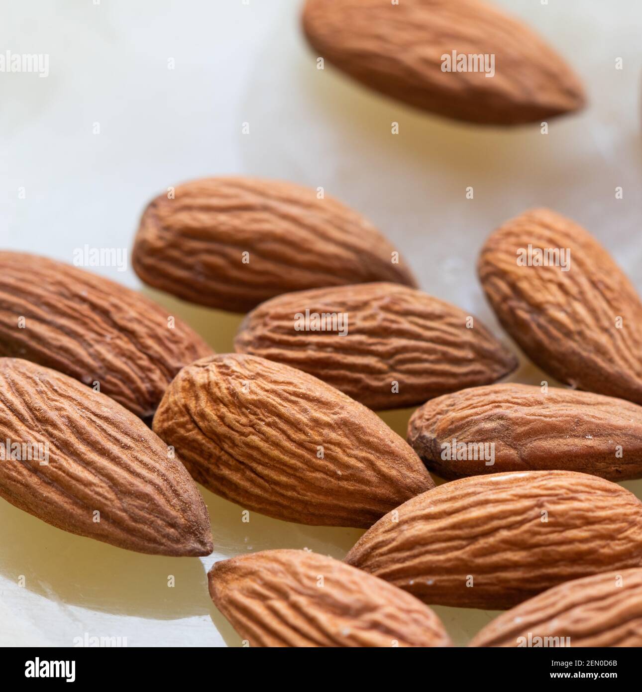 Primo piano sulle mandorle su sfondo bianco in marmo onice. Foto Stock