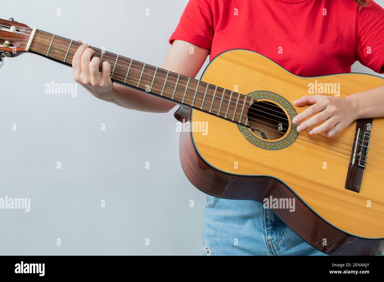 Giovane ragazza in camicia rossa con una chitarra acustica Foto Stock