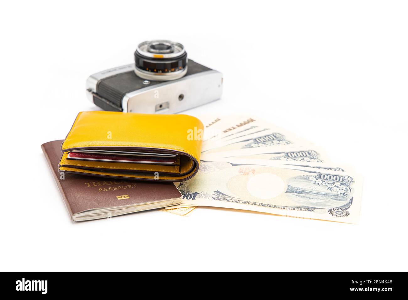 Il portafoglio di denaro giallo è stato collocato sul passaporto e le banconote e la fotocamera erano su sfondo bianco. Isolato. Foto Stock