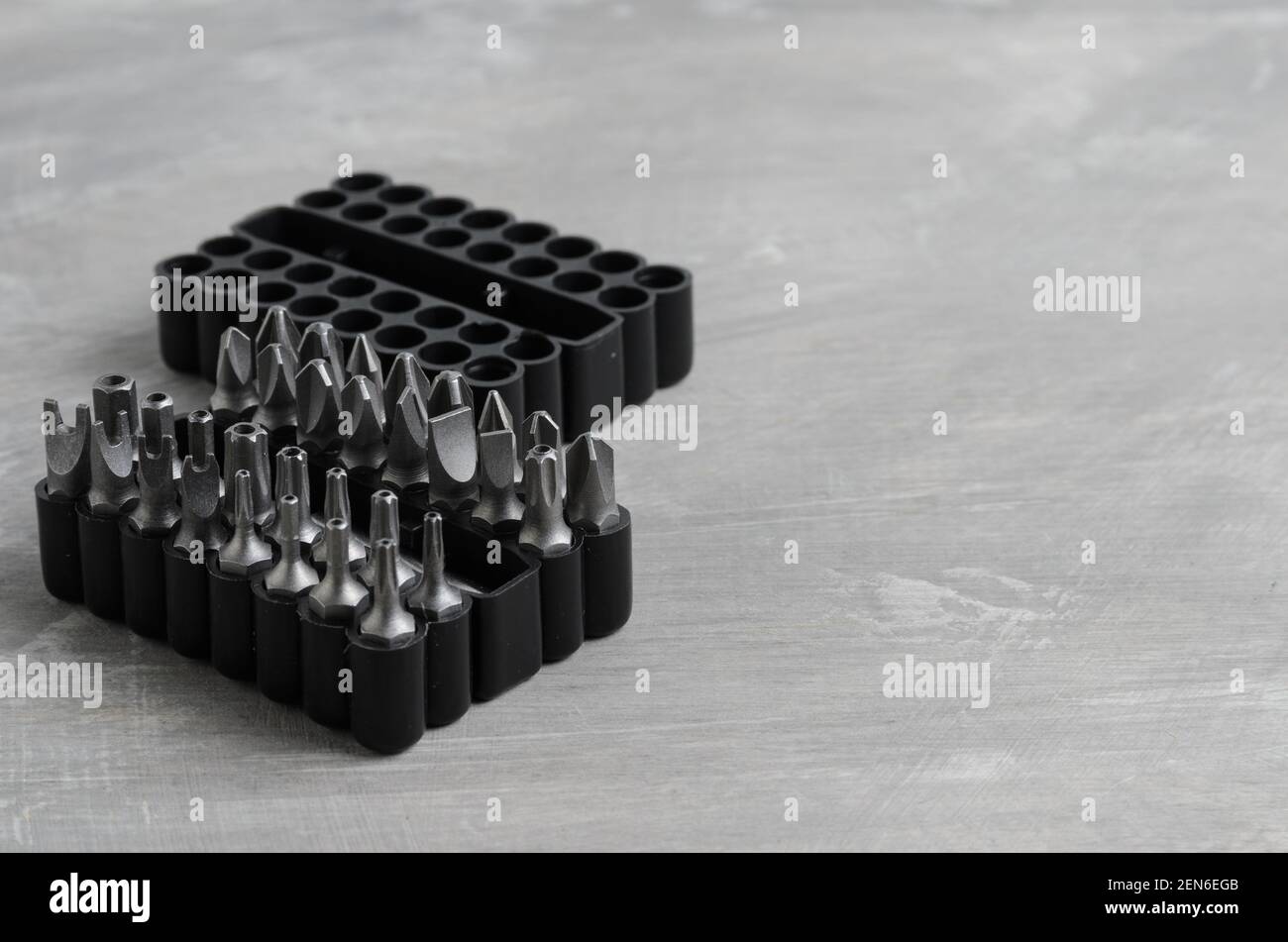 Punte per cacciaviti per vari standard in un pratico contenitore su fondo in cemento grigio. Messa a fuoco selettiva. Foto Stock