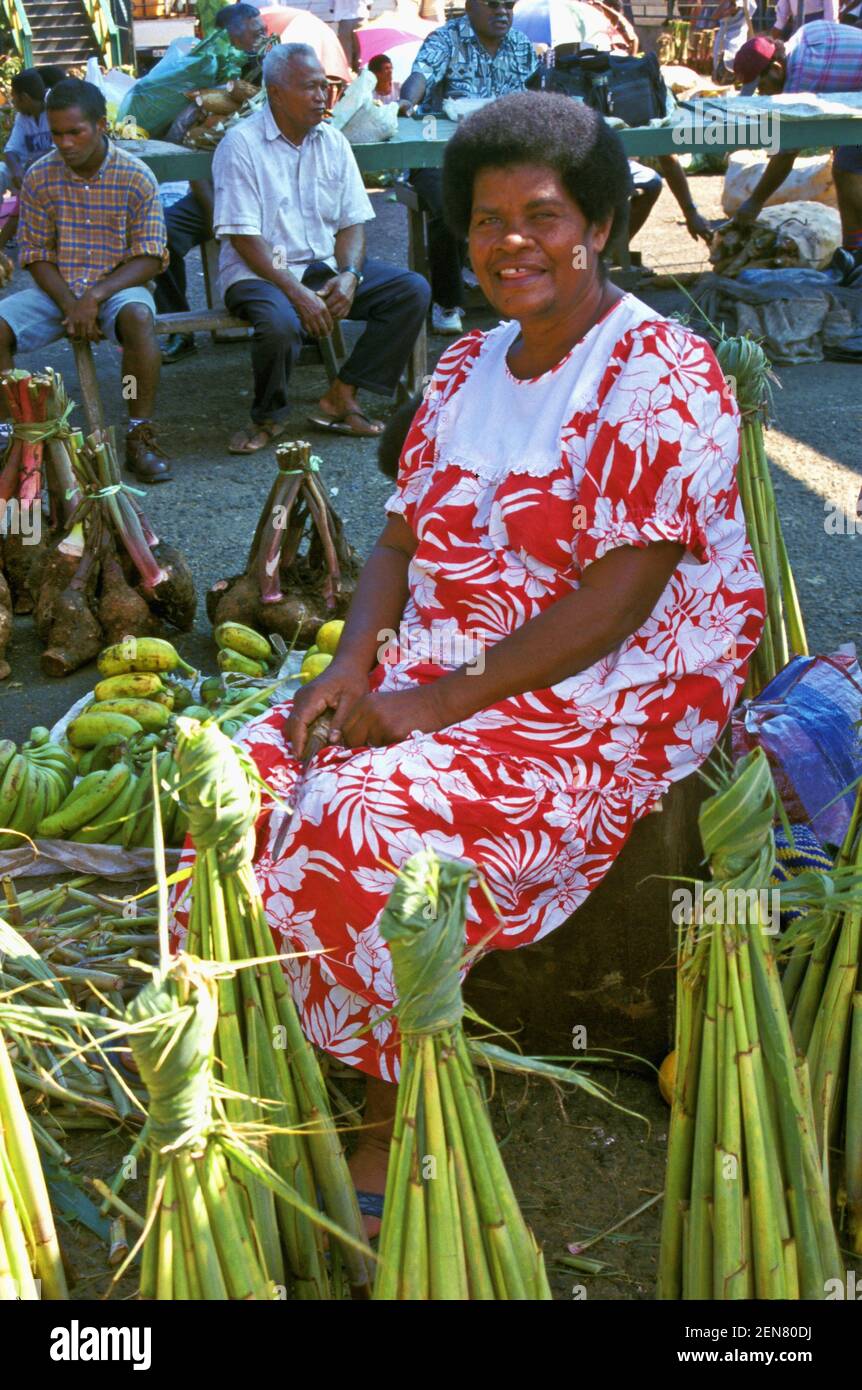 Una femmina Fiji Melanesiana stallholder con radica di taro impacchettata al mercato Municipale a Suva, Fiji Foto Stock