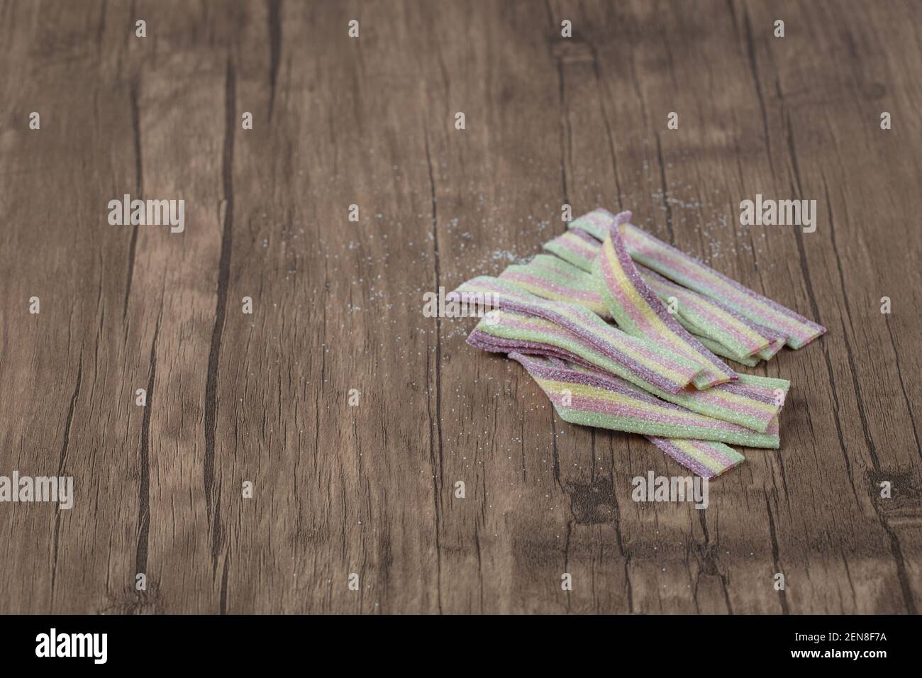 Gengive di gelatina di arcobaleno su un tavolo di legno Foto Stock