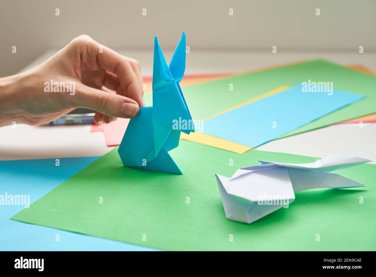 Concetto DIY. Donna fare origami coniglio di pasqua da carta a colori.  Lezioni Origami Foto stock - Alamy