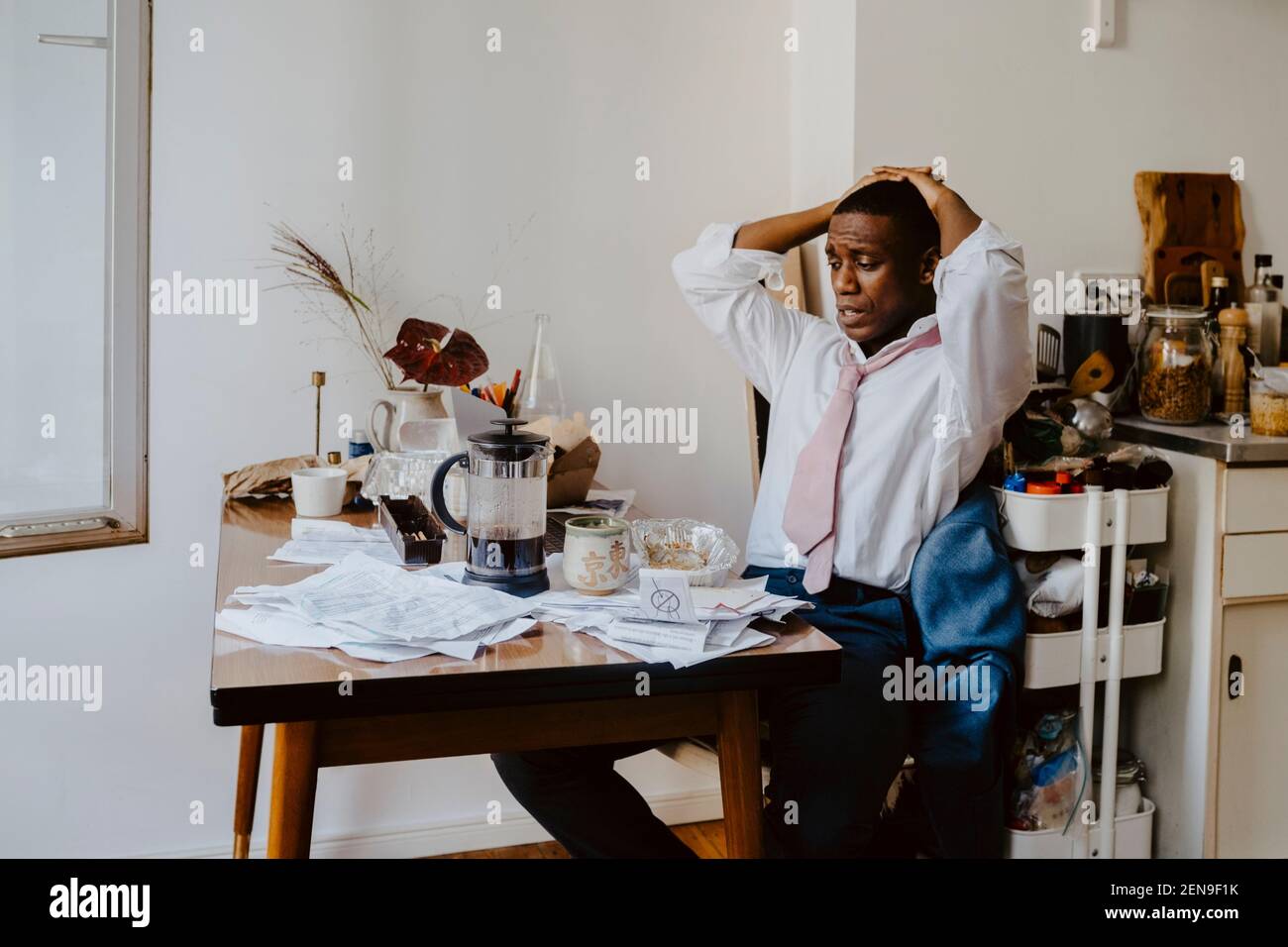 Uomo d'affari preoccupato con le mani dietro la testa che lavorano sul laptop a. tabella Foto Stock Uomo d'affari preoccupato con le mani dietro la testa che lavorano sul laptop a. tabella Foto Stock