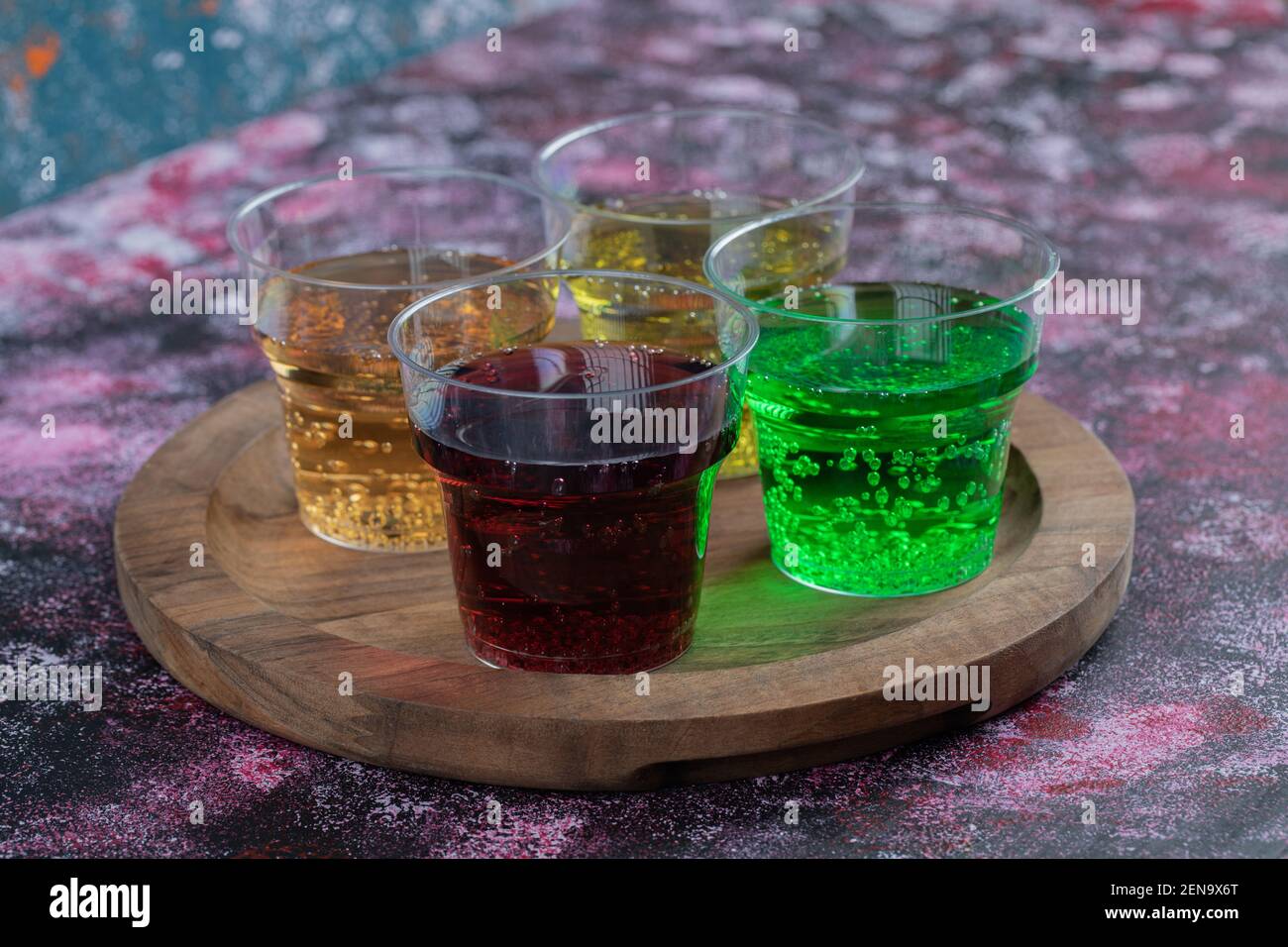 Bevande colorate in tazze su un piatto di legno Foto Stock