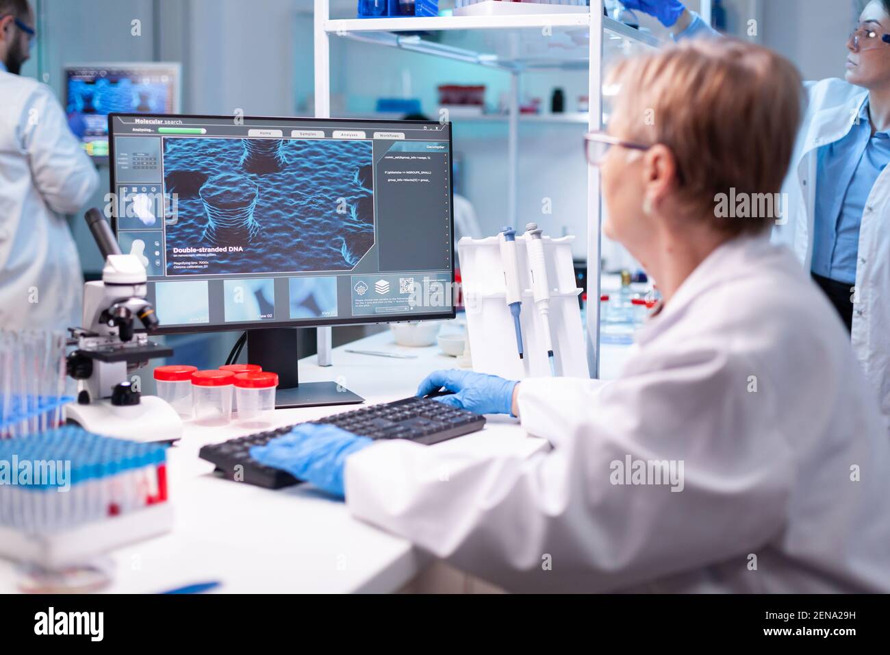 Scienziato medico analizzando un test in computer per la competenza ospedaliera. Medico senior professionista che esamina l'evoluzione del vaccino utilizzando l'alta tecnologia per la ricerca scientifica, sviluppo del trattamento contro il covid19 Foto Stock
