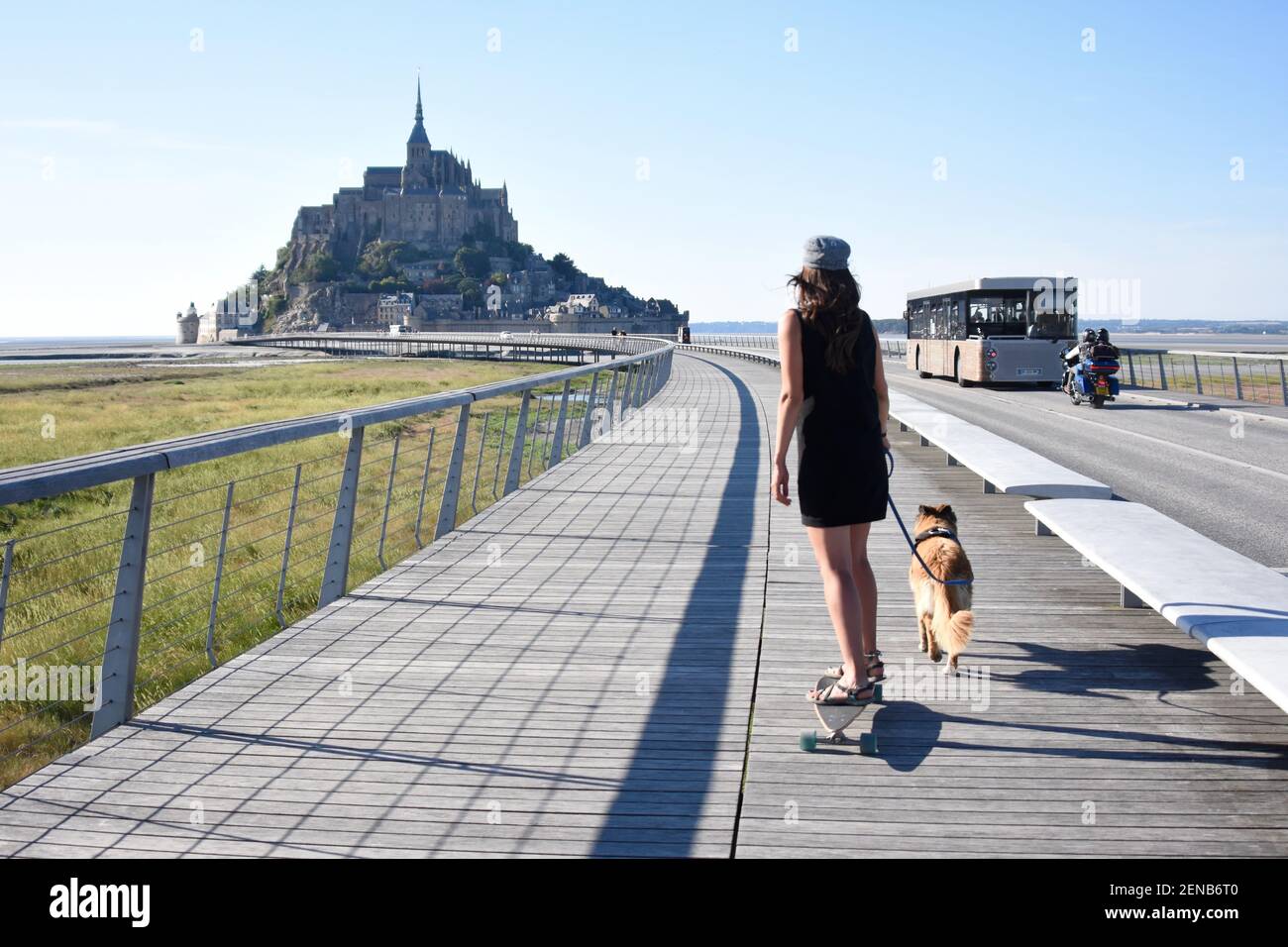 Ragazza su skateboard tirata dal cane, le mont saint michel, Francia Foto Stock