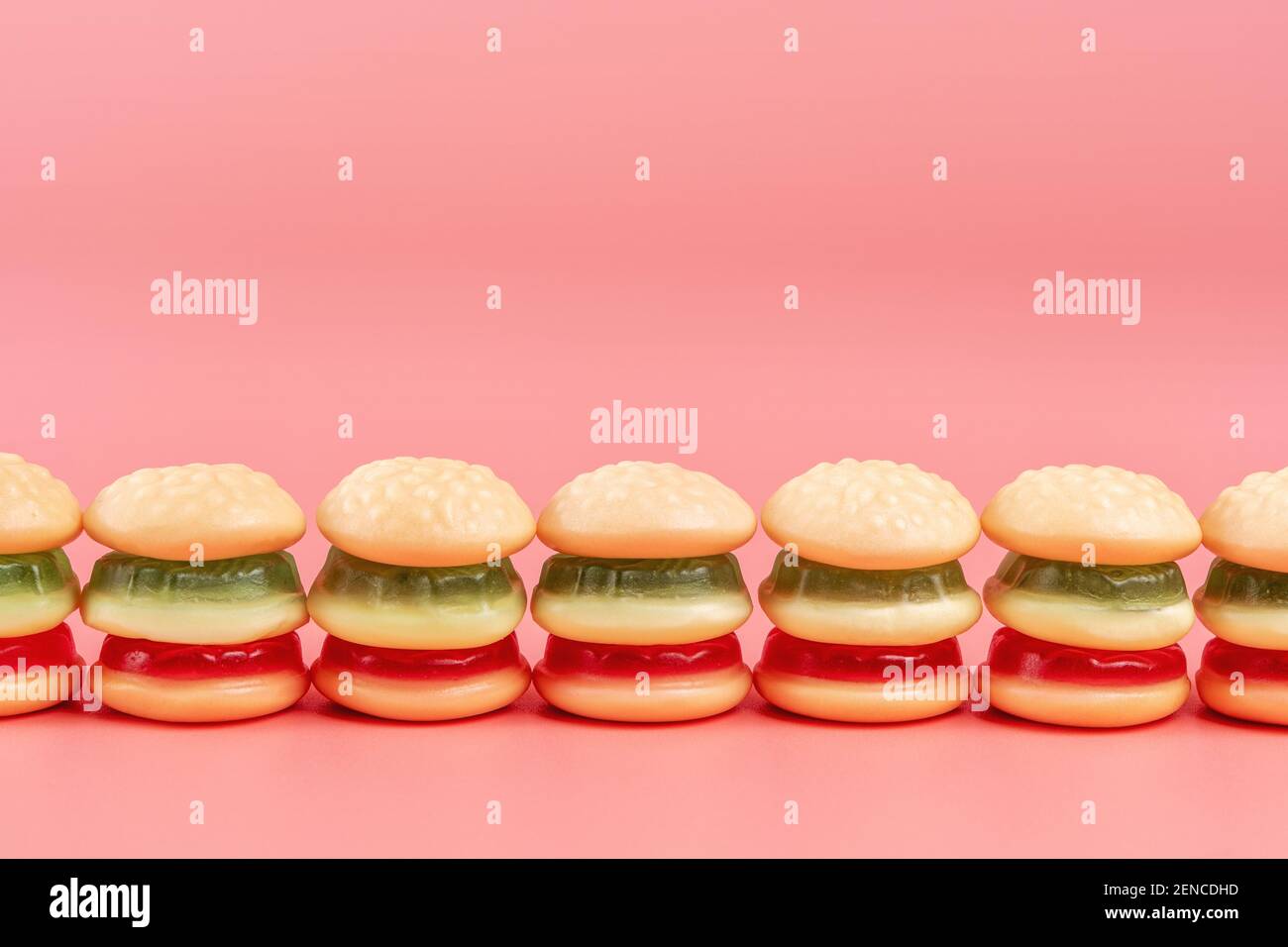 Hamburger caramelle colorate su sfondo rosa. Concetto di cibo minimo. Foto Stock