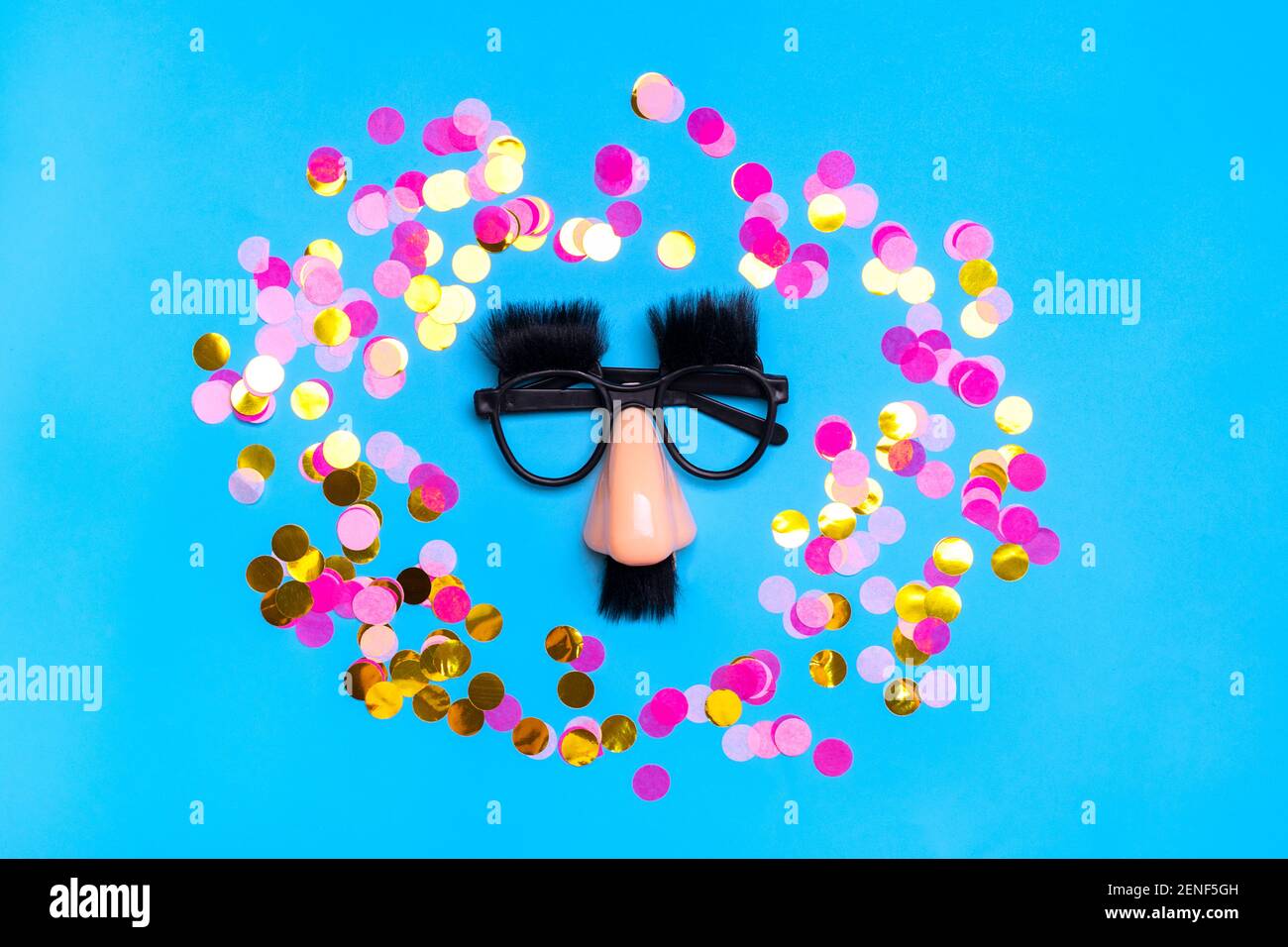 Faccia divertente - occhiali falsi, naso e baffi, confetti, paillettes su sfondo blu Happy fools Day Concept 1st April party Holiday card Foto Stock