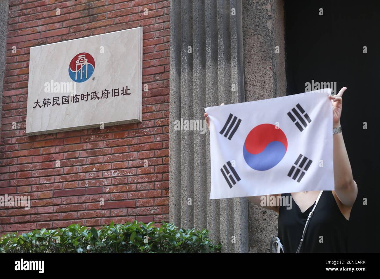 Un turista sudcoreano posa per foto con la sua bandiera nazionale di fronte  al sito del governo provvisorio coreano per saperne di più sulla storia tra  il Giappone e la Corea del