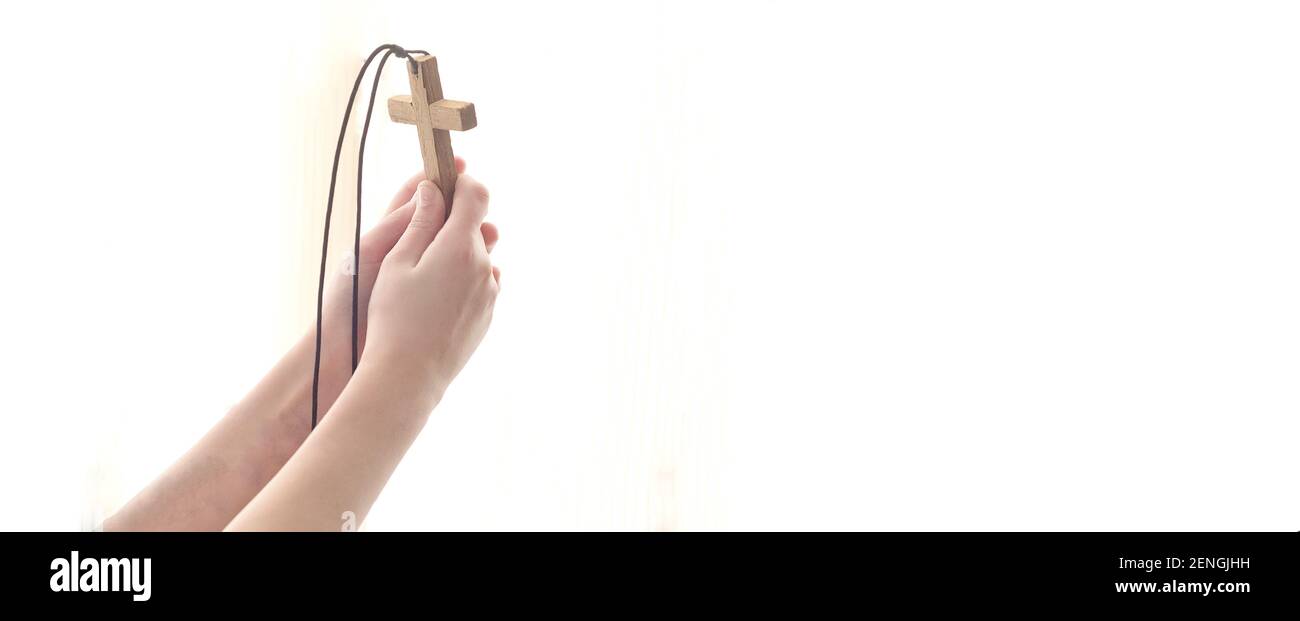 Mani distese con una croce a Dio nella luce. Foto Stock