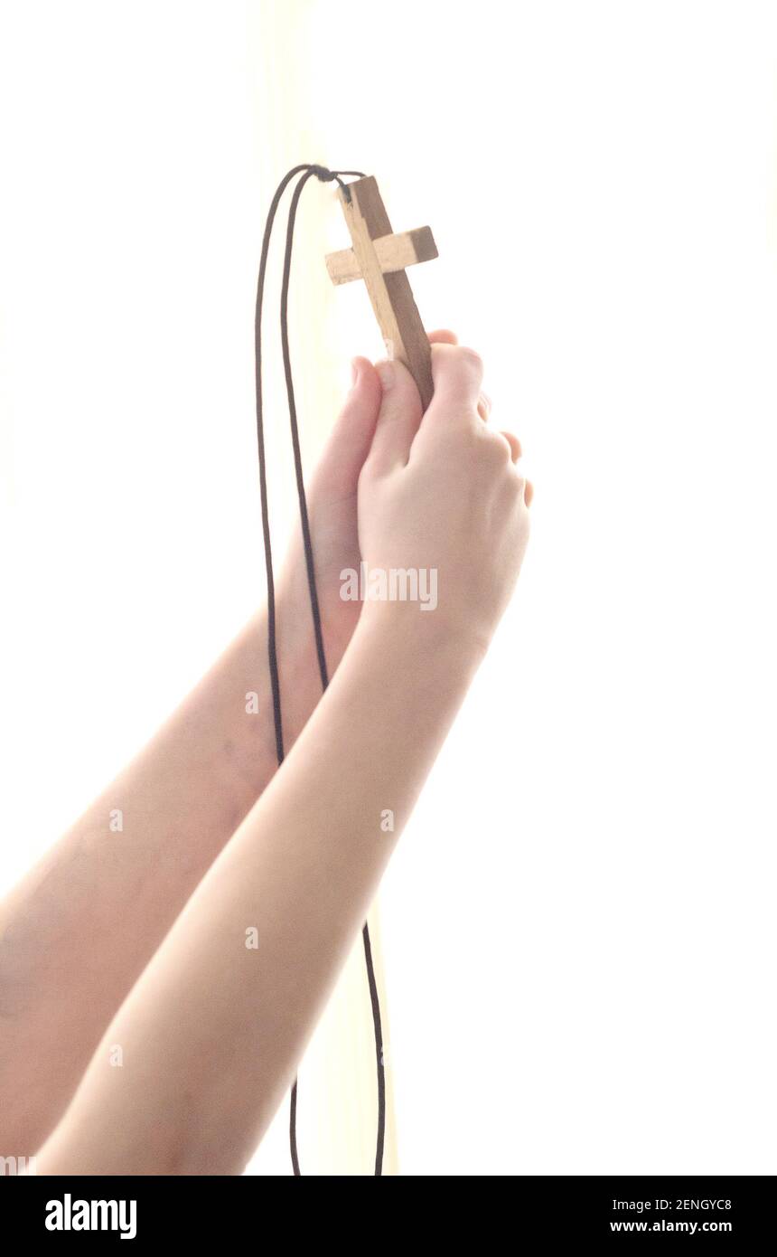 Mani distese con una croce a Dio nella luce. Foto Stock