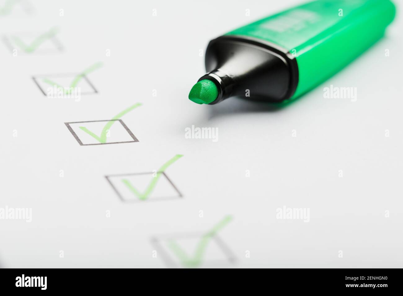 Il contrassegno verde sulla scheda di controllo con i contrassegni sotto forma di segni di spunta. Concetti di produzione Foto Stock