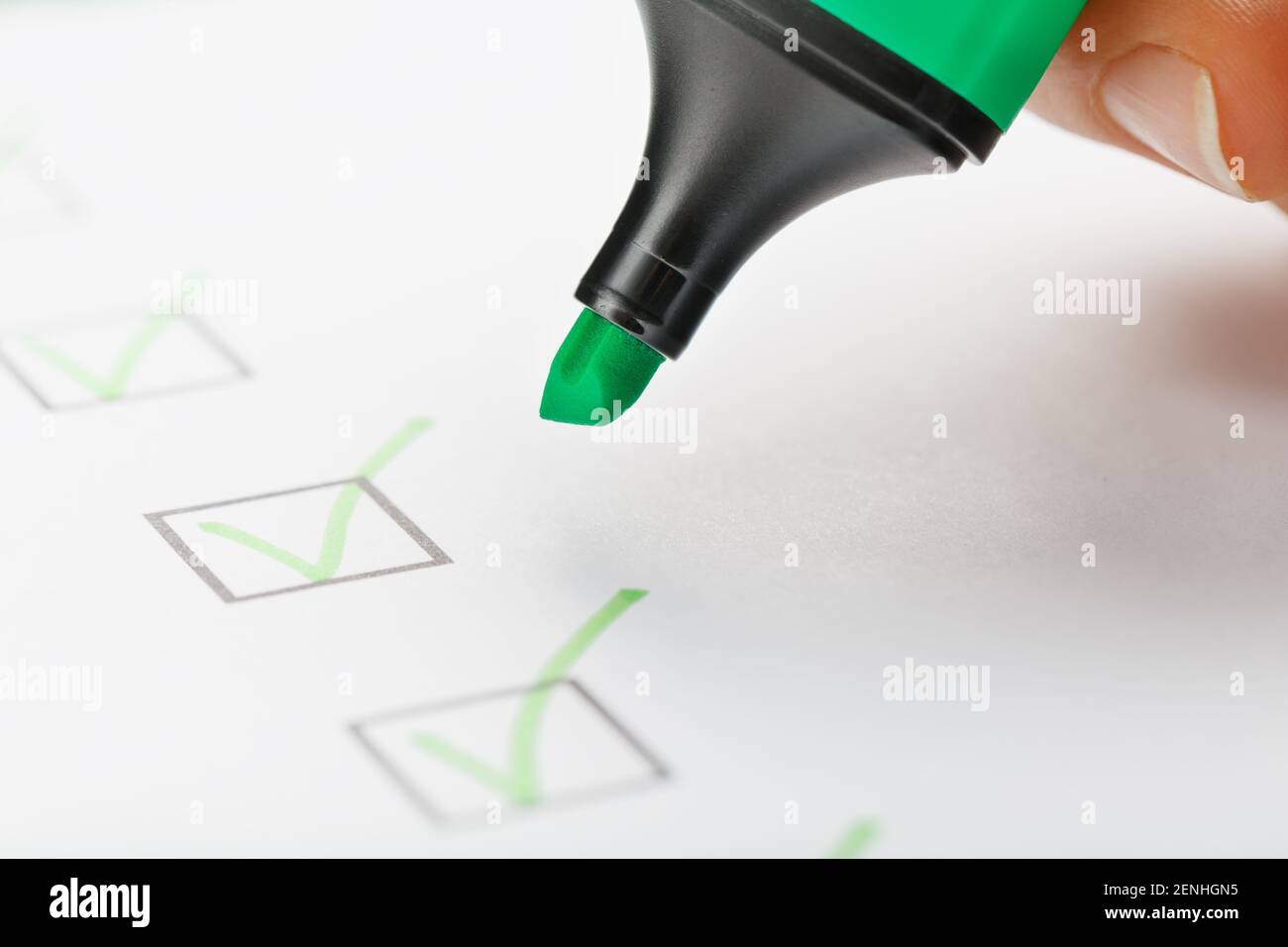 Il contrassegno verde sulla scheda di controllo con i contrassegni sotto forma di segni di spunta. Concetti di produzione Foto Stock