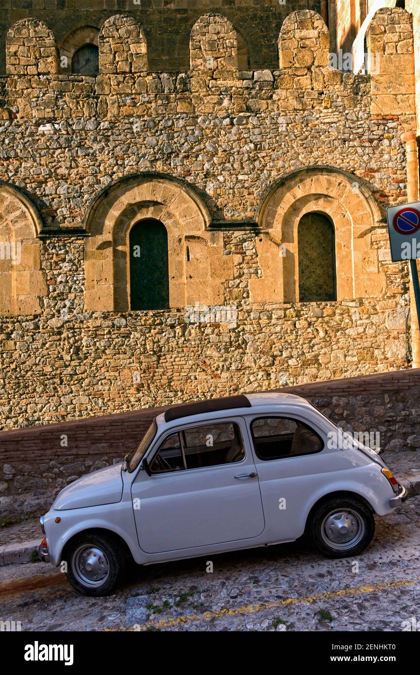 Italia,Sicilia,Cefalù, antica Fiat Cincocento 500 auto parcheggiata una strada acciottolata contro una struttura medievel Foto Stock