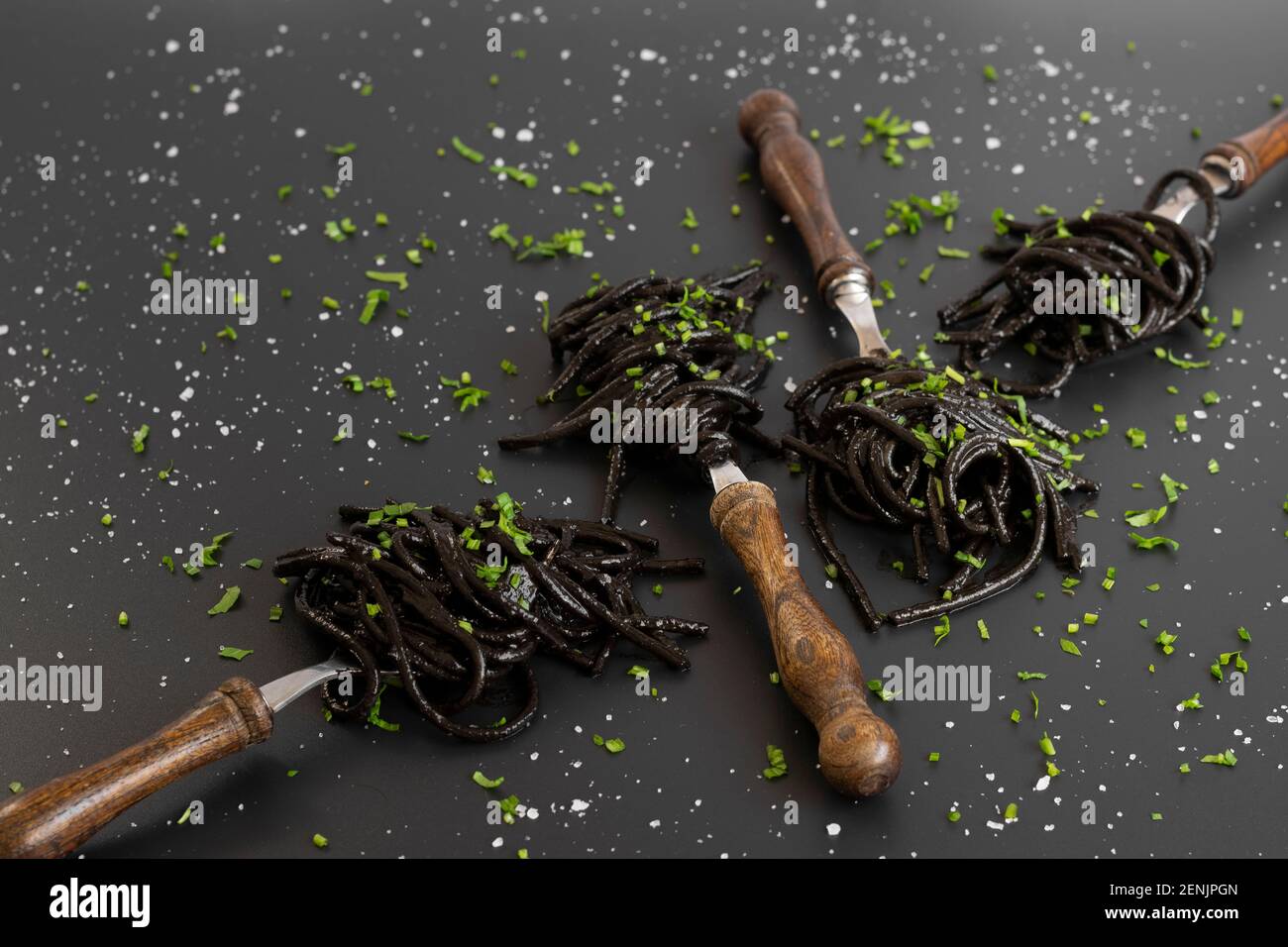 Spaghetti neri con inchiostro di seppie. Pasta di pesce nera su sfondo scuro. Gastronomia mediterranea. Foto Stock