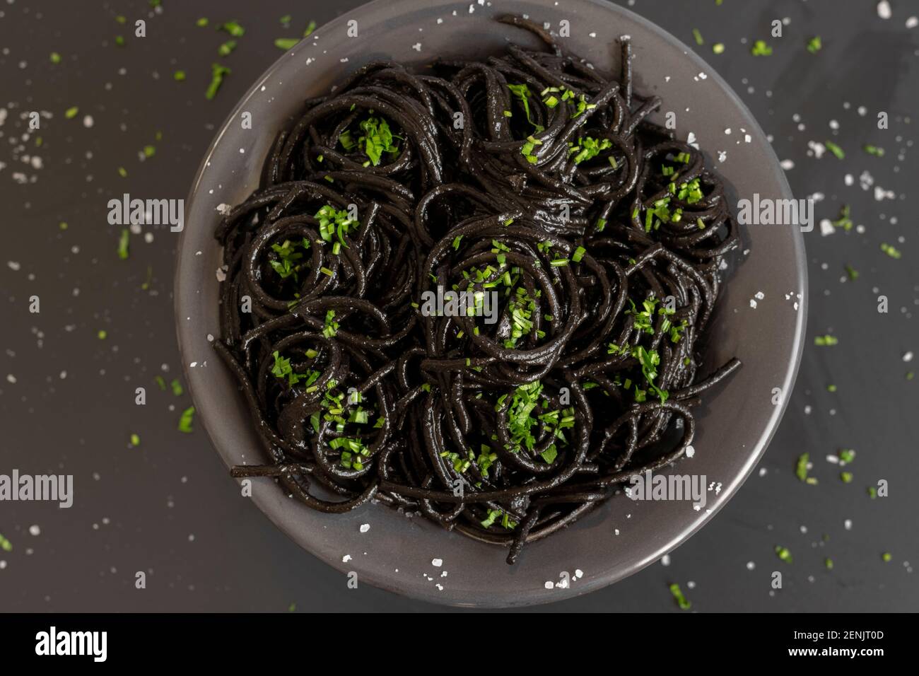Spaghetti neri con inchiostro di seppie. Pasta di pesce nera su sfondo scuro. Gastronomia mediterranea. Foto Stock