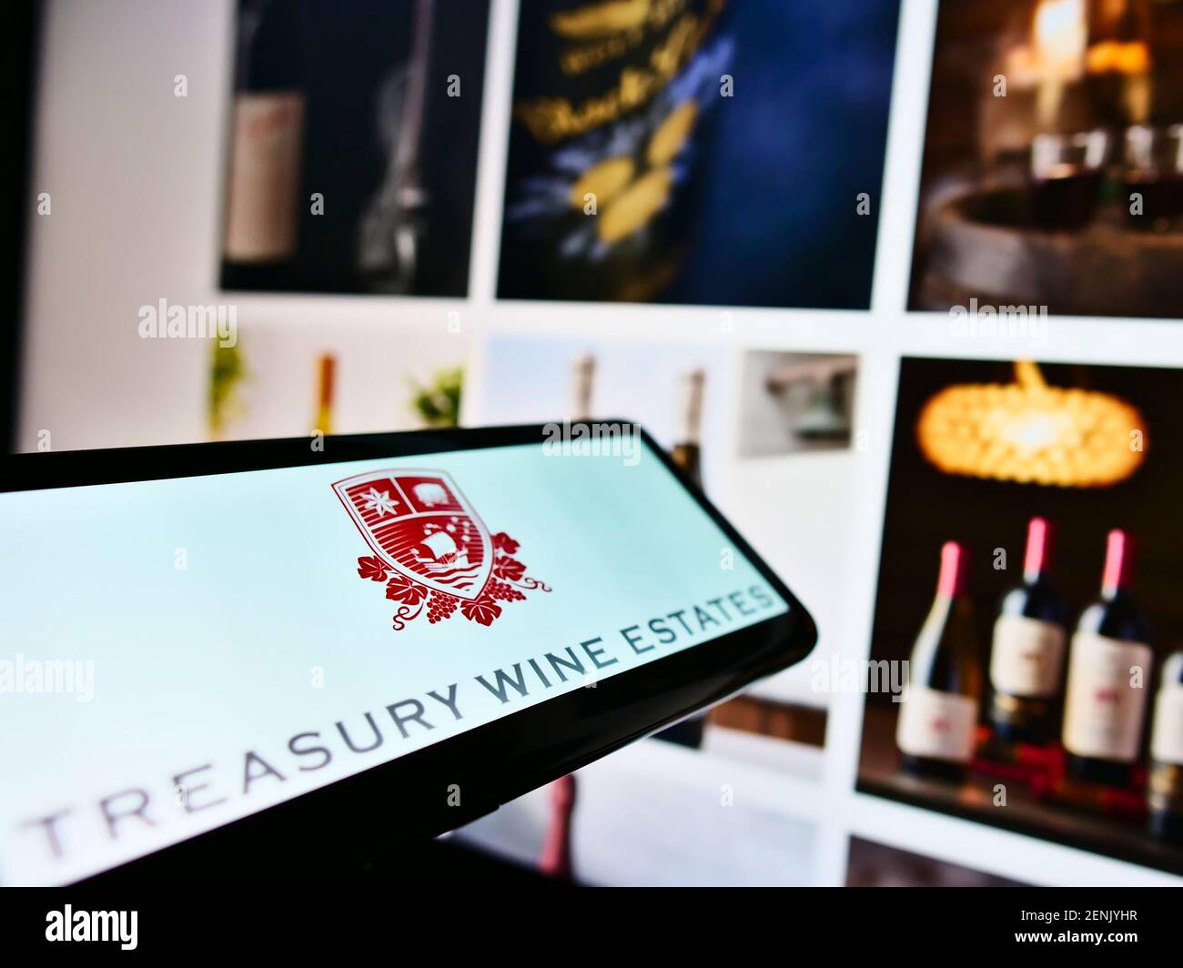 Cellulare con logo della società vinicola australiana Treasury Wine Estates Limited sullo schermo davanti alla pagina web. Mettere a fuoco il centro del display del telefono. Foto Stock