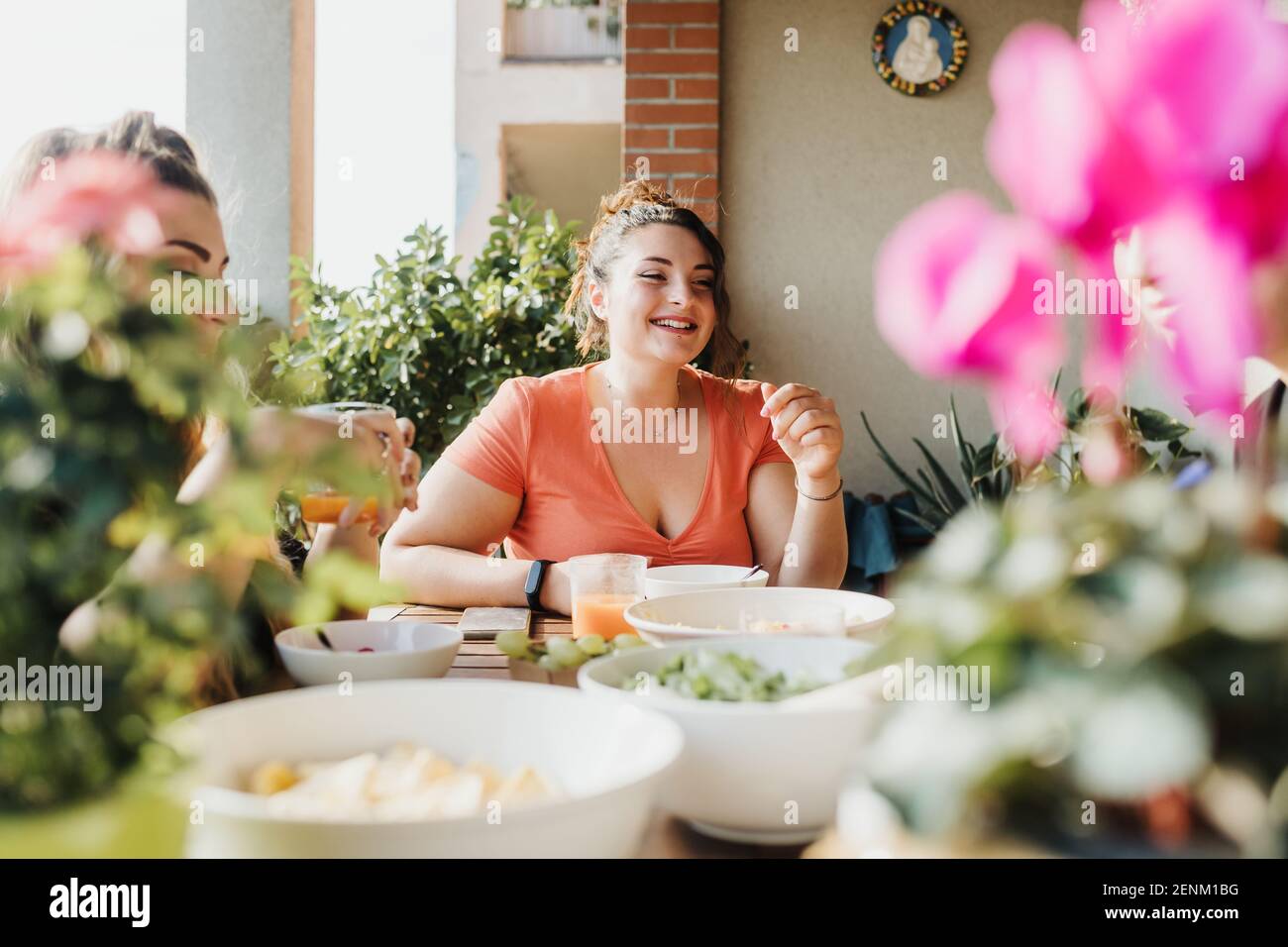 Giovane donna al pasto sul balcone Foto Stock