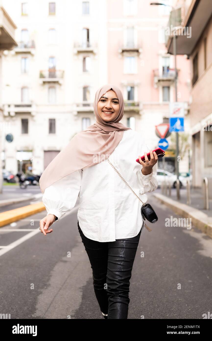 Giovane musulmana che cammina in città Foto Stock
