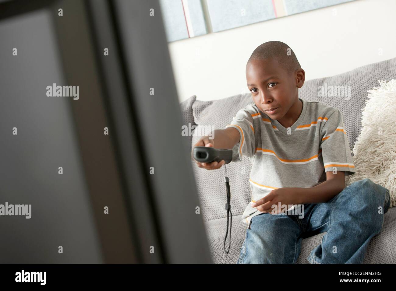 Ragazzo cambiare canale tv Foto Stock