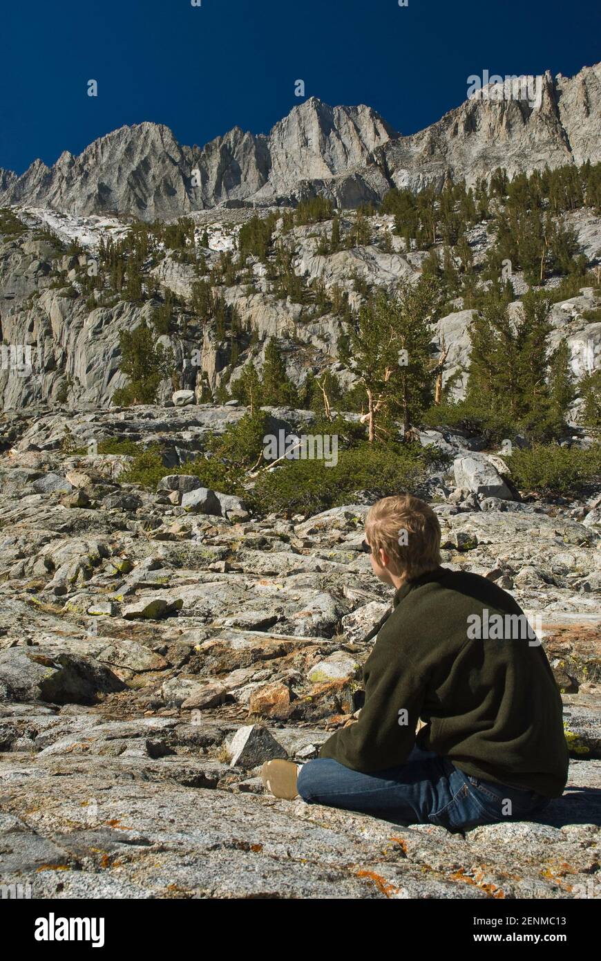 Giovane escursionista che guarda il Palisade Medio da zona vicino al lago Brainard, la regione di Palisades, John Muir Wilderness, Sierra Nevada orientale, California USA Foto Stock