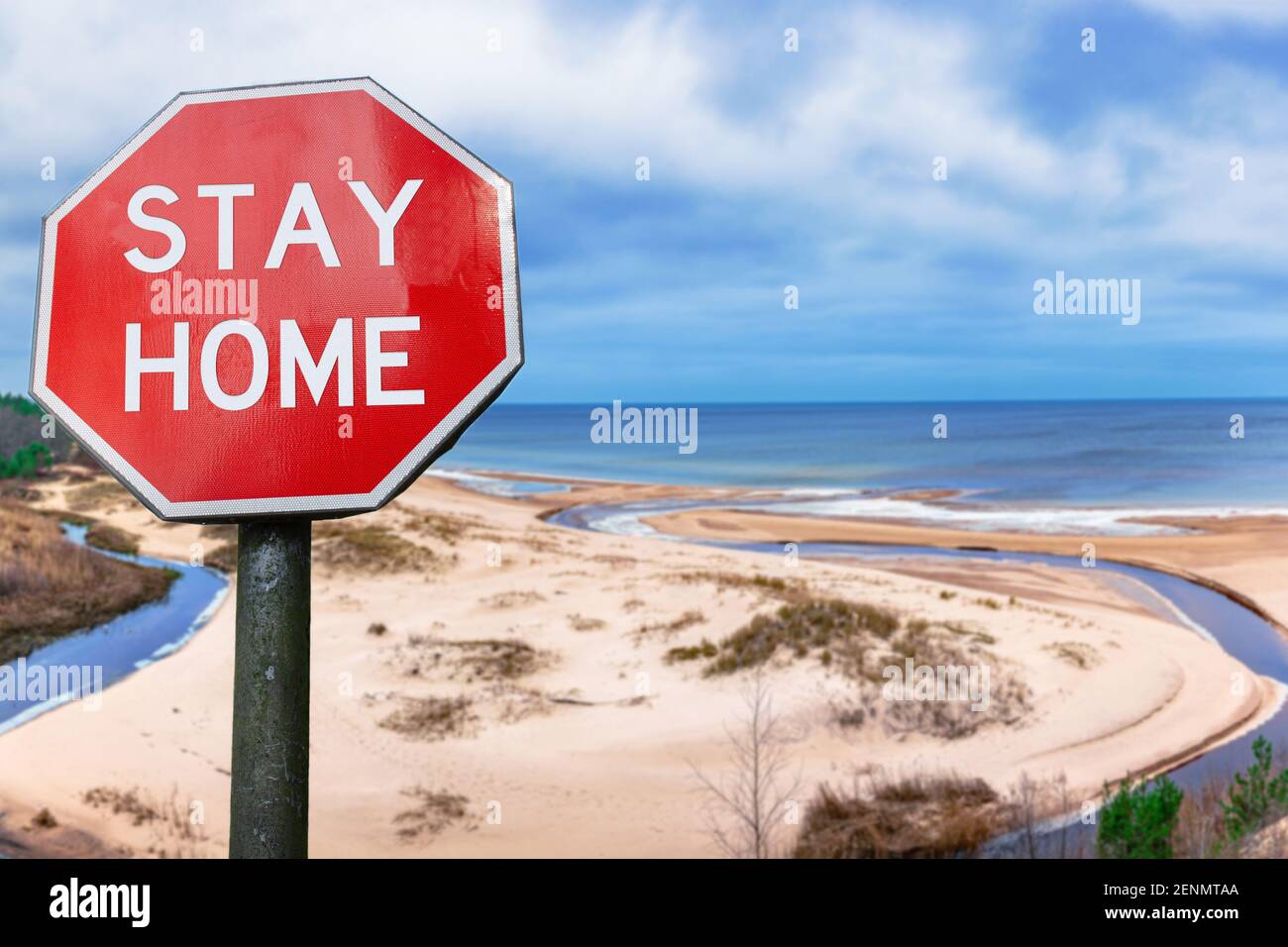 Soggiorno segno casa contro la vista della spiaggia di sabbia bianca e il mare circondato da conifere alberi foresta. Foto Stock