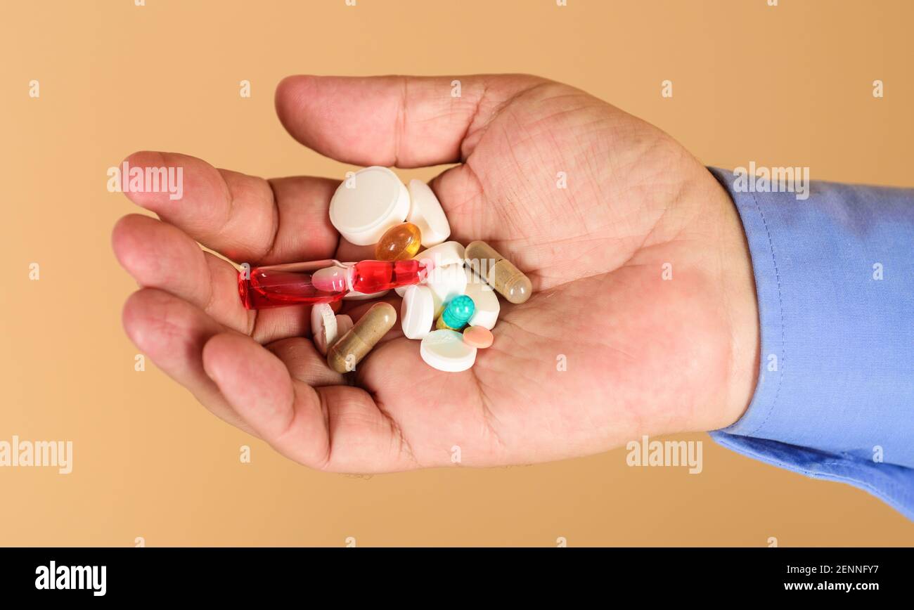 L'uomo mani con pillole. Medicina, trattamenti e assistenza sanitaria. Compresse in mano al paziente. Foto Stock
