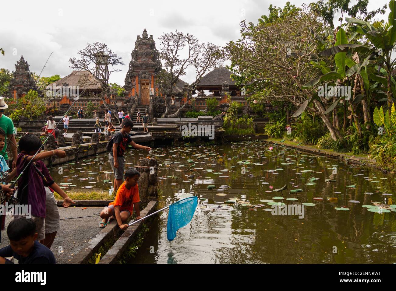 I bambini pescano al tempio di Saraswati (Palazzo di Ubud) Dal laghetto di loto Foto Stock
