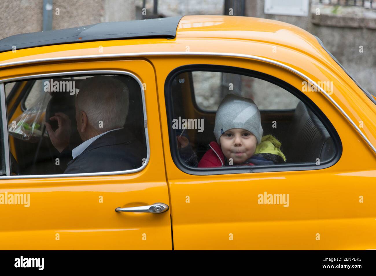 un ragazzino che si sbirciava dal sedile posteriore di Una Fiat 500 Foto Stock