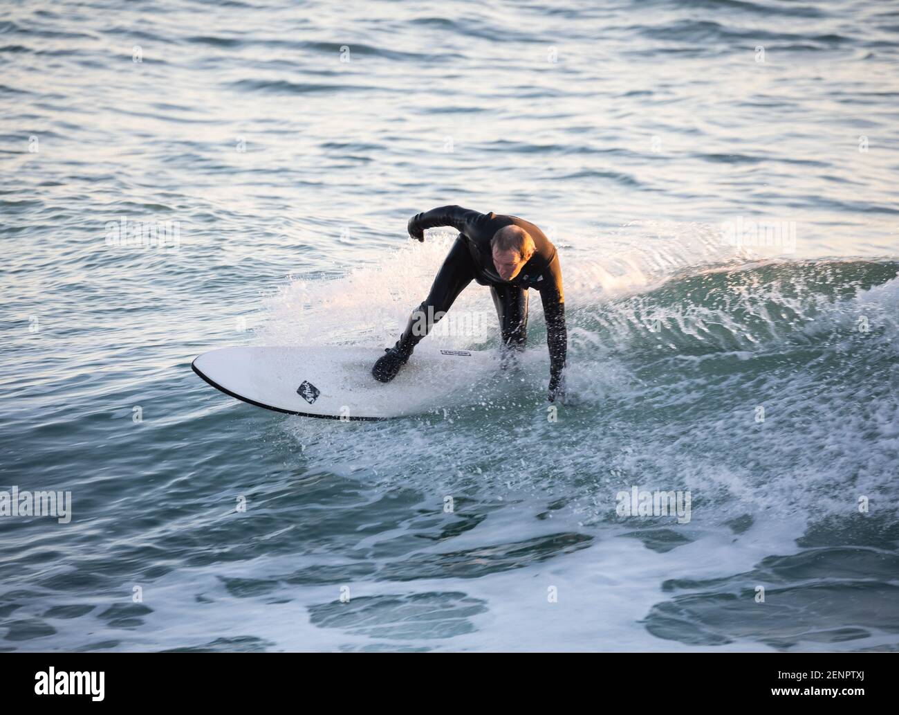 Porthleven, Cornovaglia, 26 febbraio 2021, Surfers sfruttare al massimo il glorioso sole del tardo pomeriggio a Porthleven, Cornovaglia, la gente stava nuotando e tuffandosi nel porto. La temperatura era di 10C e il sole è quello di continuare le previsioni per i prossimi giorni.Credit: Keith Larby/Alamy Live News Foto Stock